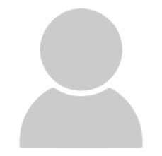 Team member in blue shirt seated at desk with laptop, representing technical expertise.