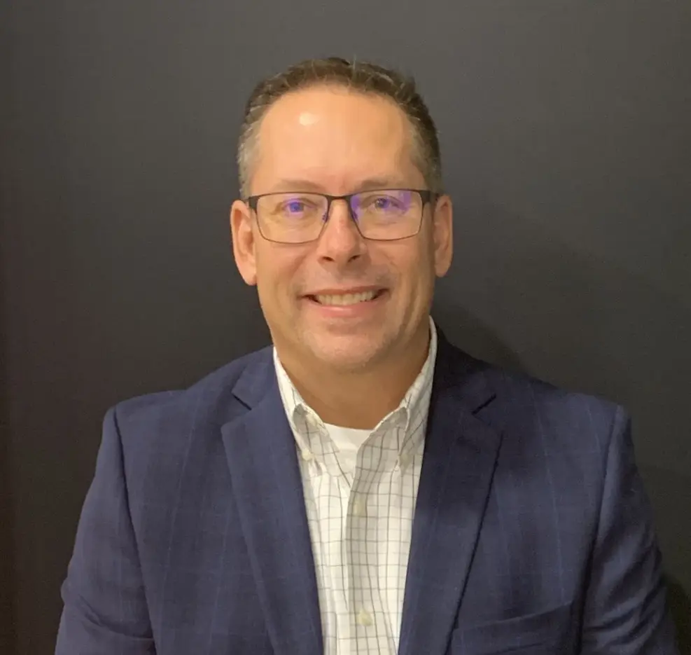 Team member in leadership position, photographed in professional office setting.
