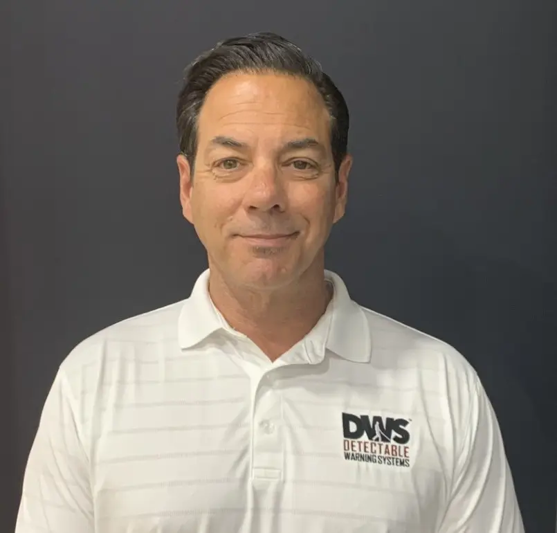 Professional headshot of team member wearing business suit with neutral backdrop.