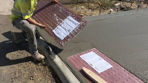 Worker Installing Red Tactile Paving Panel